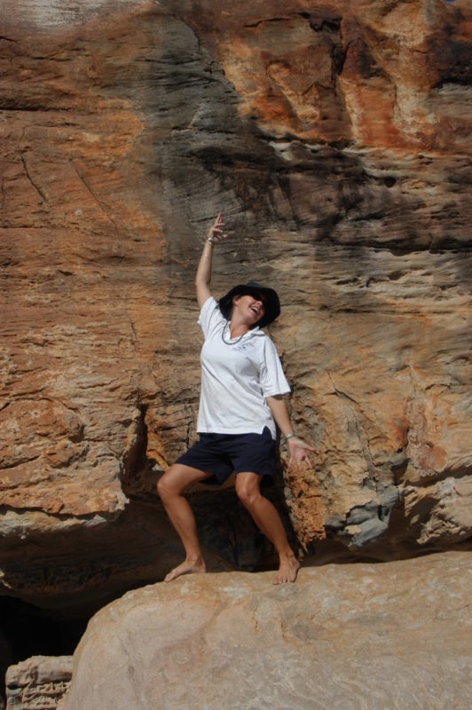 A woman posing in front of a rock face