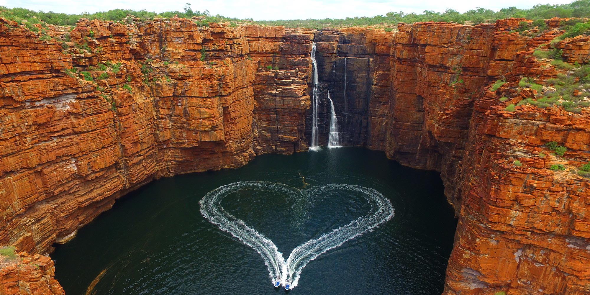 Aerial view of two tenders making a heart shape with the wake of the boats