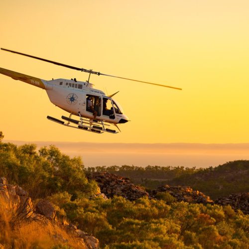 Great Escape Salty Wings helicopter in flight at sunset