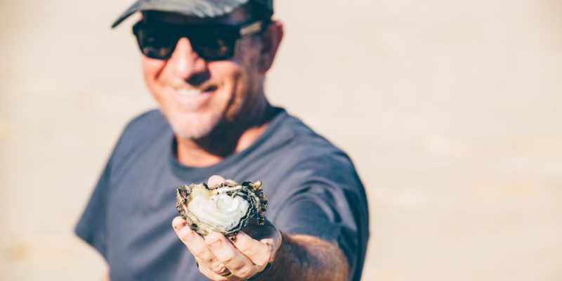 Man offering an oyster in shell