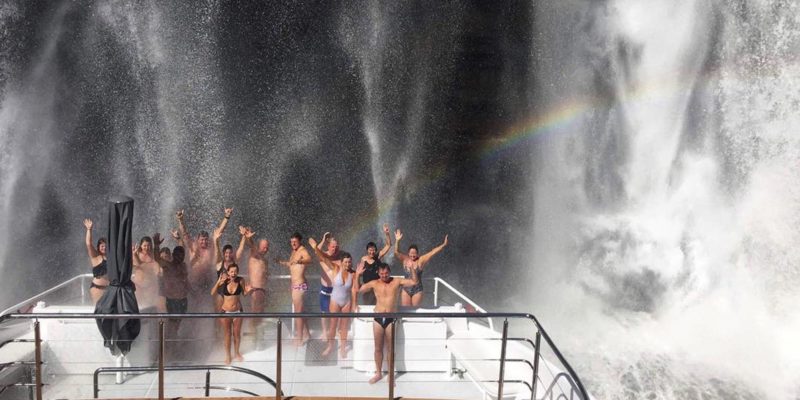 Great Escape guests being showered by waterfall spray on the top deck
