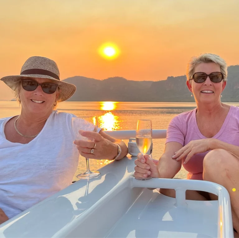 Friends enjoying a champagne on a Great Escape Cruises boat at sunset